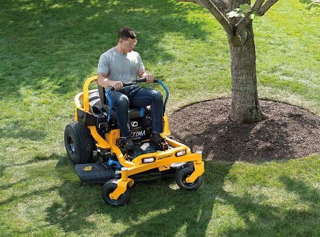 Man on zero turn mower near tree